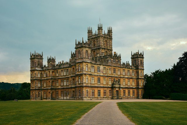 Highclere Castle surrounded by green parkland and trees in Berkshire